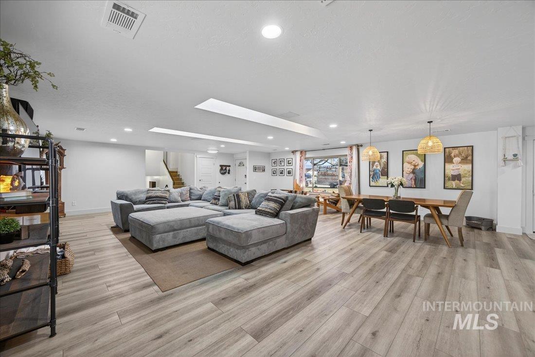 4393 North Edelweiss Street Boise, ID 83713 - Photo 8 of 42 Living room with recessed lighting, light wood-style flooring, stairs, a textured ceiling, and a skylight