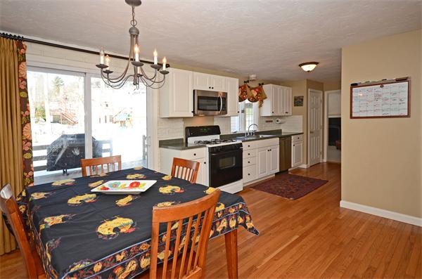 16 Nicholas Road Hopkinton, MA 01748 - Photo 10 of 28 a kitchen with stainless steel appliances granite countertop a stove top oven a sink dishwasher and a dining table with wooden floor