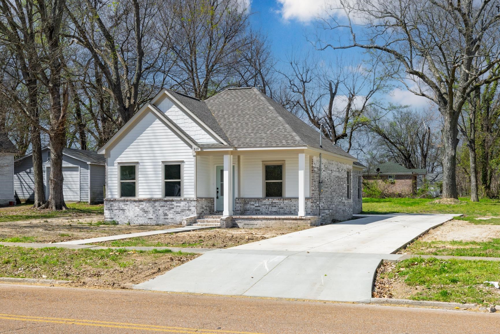 319 North Maple Street Covington, TN 38019 - Photo 2 of 32 View of front of property with brick siding, covered porch, and roof with shingles