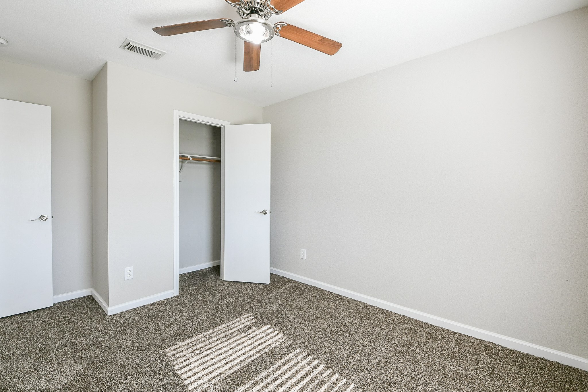 20807 Lansing Ridge Lane Katy, TX 77449 - Photo 18 of 35 This room features neutral walls, a ceiling fan, and plush carpet. It has a closet with a white door and ample natural light, creating a bright and inviting space.