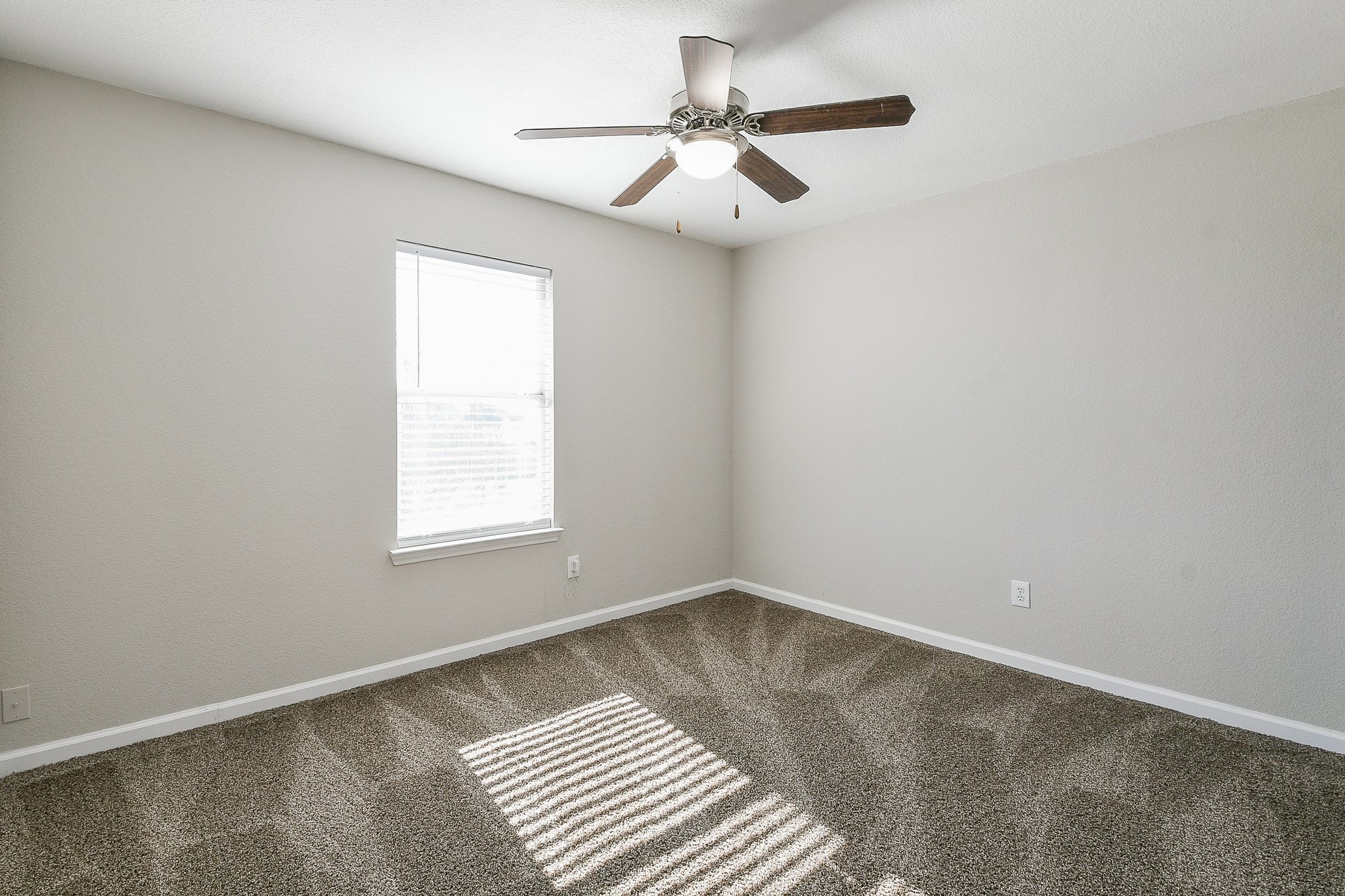 20807 Lansing Ridge Lane Katy, TX 77449 - Photo 21 of 35 This room features neutral-colored walls, plush carpet, a ceiling fan, and a window that lets in natural light, creating a bright and inviting space.