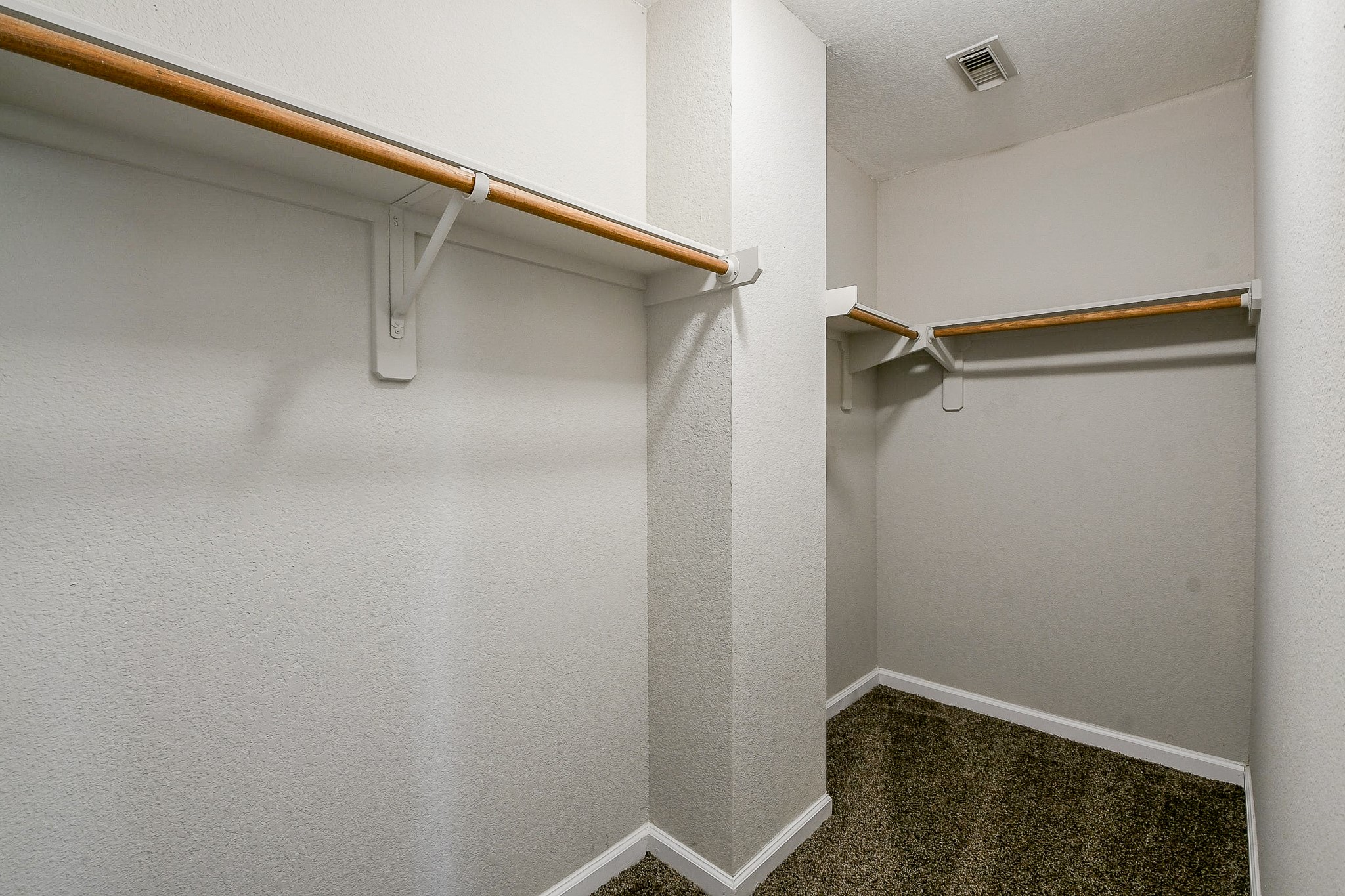 20807 Lansing Ridge Lane Katy, TX 77449 - Photo 29 of 35 Spacious walk-in closet with dual hanging rods and ample shelving, featuring neutral walls and carpeted flooring.