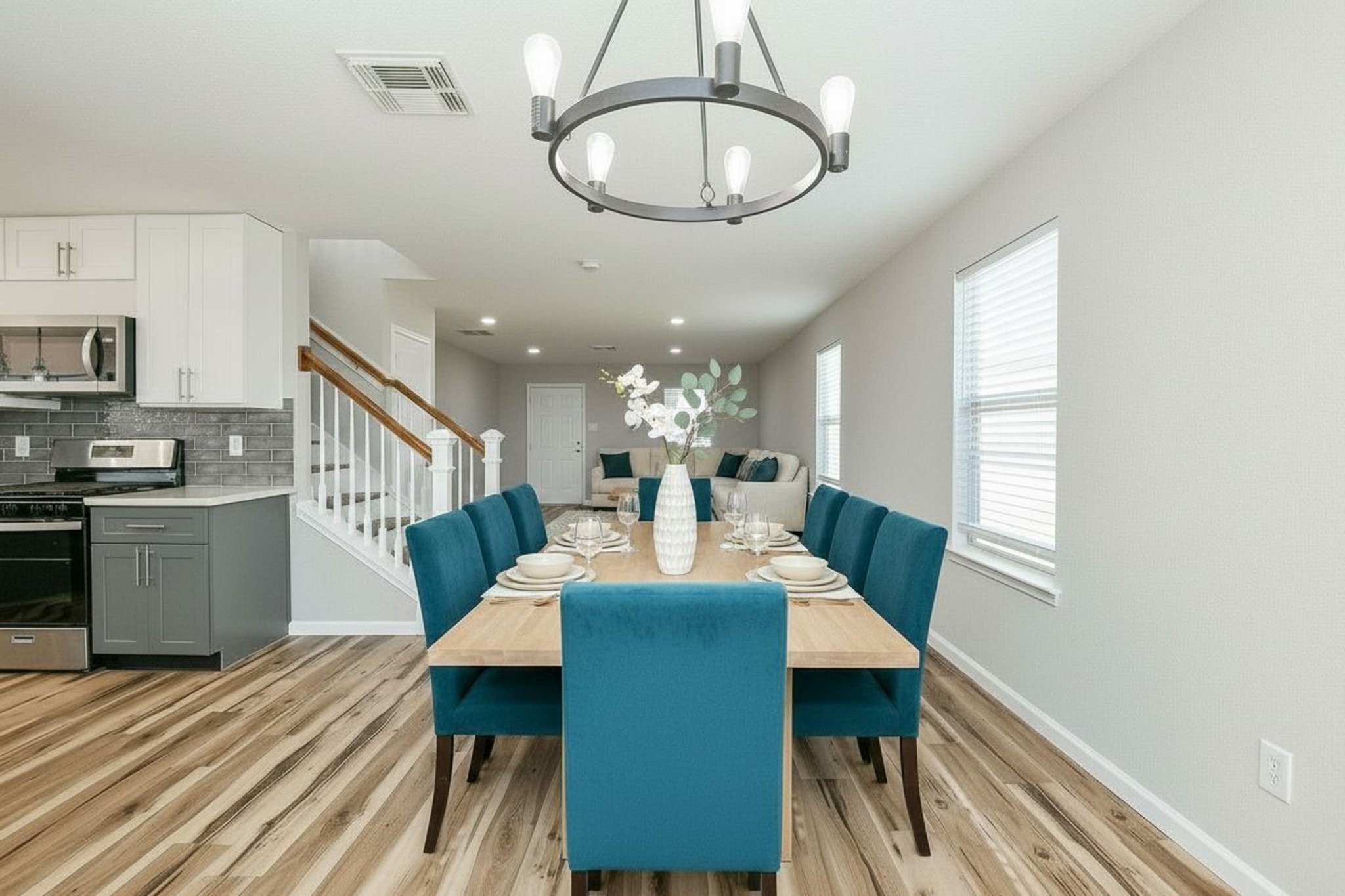 20807 Lansing Ridge Lane Katy, TX 77449 - Photo 9 of 35 Experience modern elegance in this virtually staged, open-concept dining area, featuring sleek finishes, vibrant teal accents, and inviting natural light.