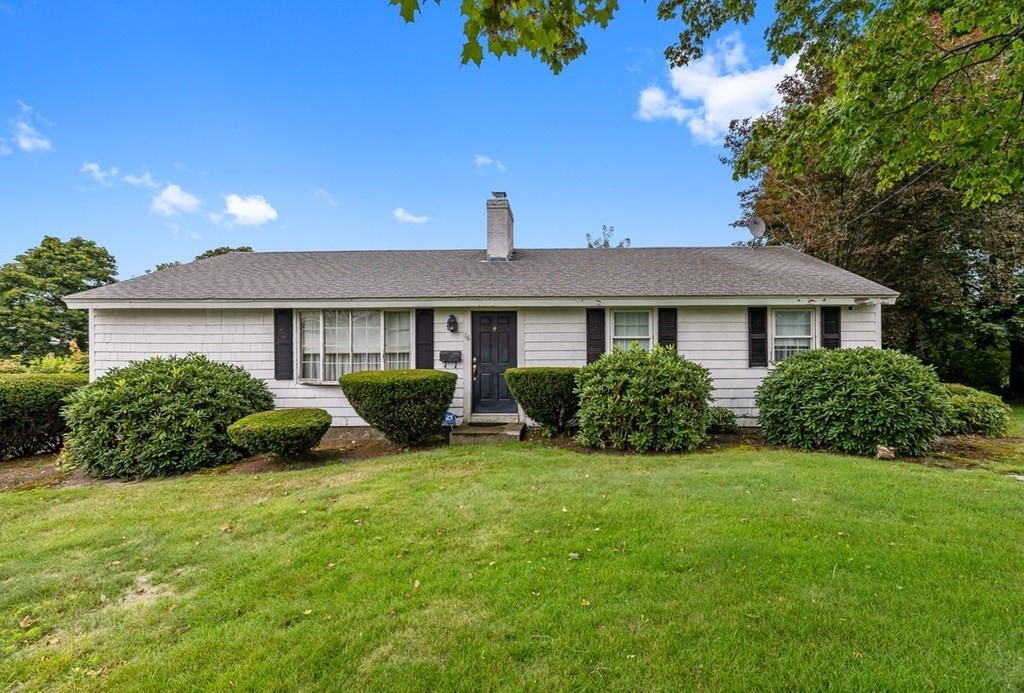 a view of a house with a yard and potted plants