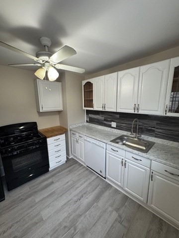 52 Curve Street, Unit 52 Dedham, MA 02026 - Photo 4 of 11 a kitchen with granite countertop a stove a sink and dishwasher with wooden floor
