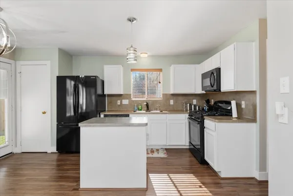 a kitchen with stainless steel appliances granite countertop a refrigerator stove top oven and sink