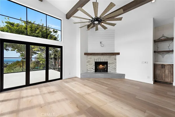 a view of an empty room with a fireplace and a window