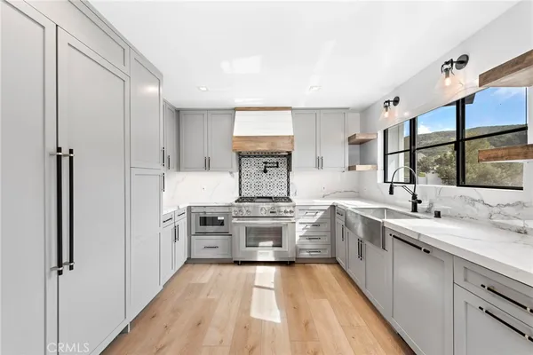 a large kitchen with stainless steel appliances granite countertop a stove and a sink