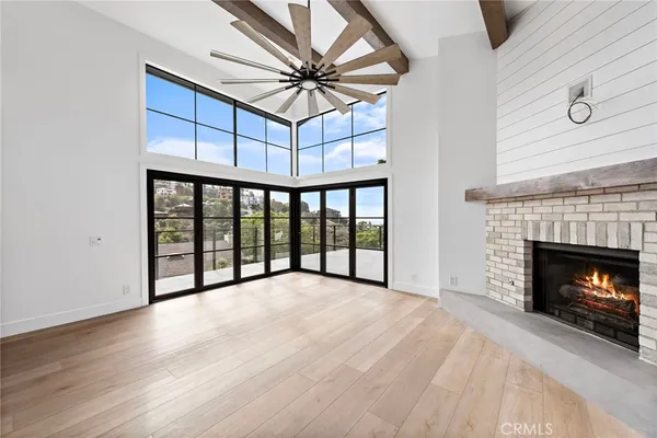 a view of an empty room with a fireplace and a window