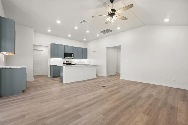 a view of kitchen with microwave and white cabinets