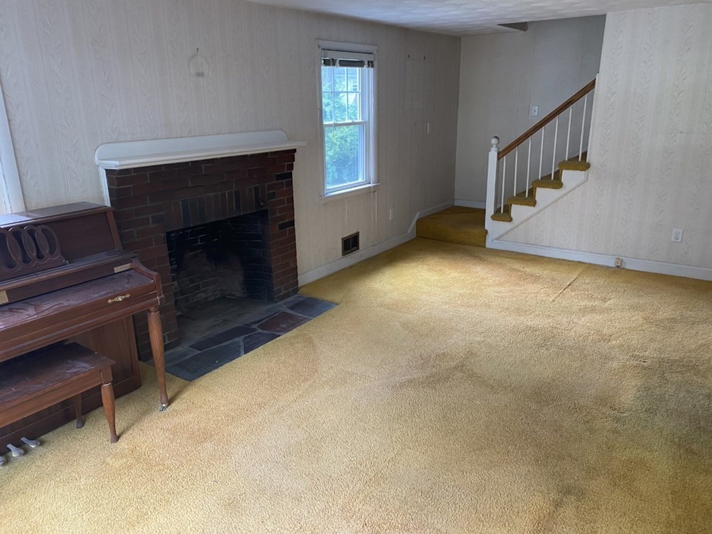 45 Glenellen Road Boston, MA 02132 - Photo 3 of 10 a view of an empty room with wooden floor fireplace and a window