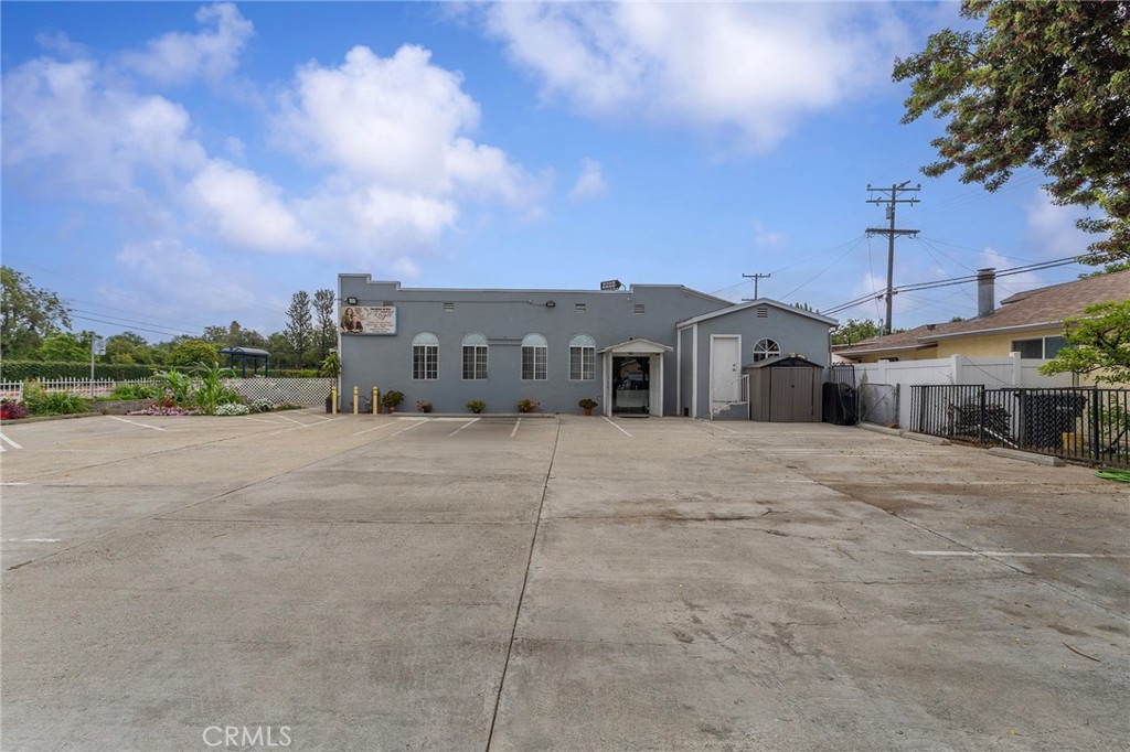 6408 Perry Road Bell Gardens, CA 90201 - Photo 11 of 32 a view of a white house with a big yard and large trees