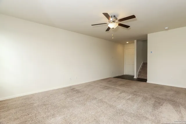 an empty room with window and ceiling fan