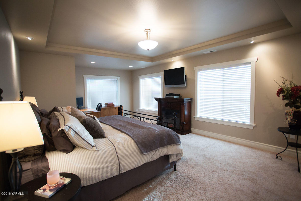 14750 Fisk Road Yakima, WA 98908 - Photo 22 of 35 a spacious bedroom with a bed and a table in it
