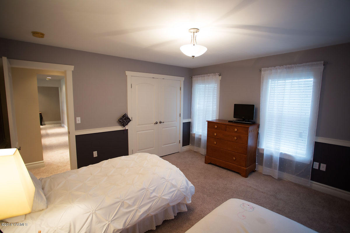 14750 Fisk Road Yakima, WA 98908 - Photo 30 of 35 a bedroom with a bed and a flat tv screen on dresser