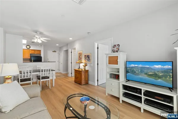 a living room with furniture a flat screen tv and kitchen view