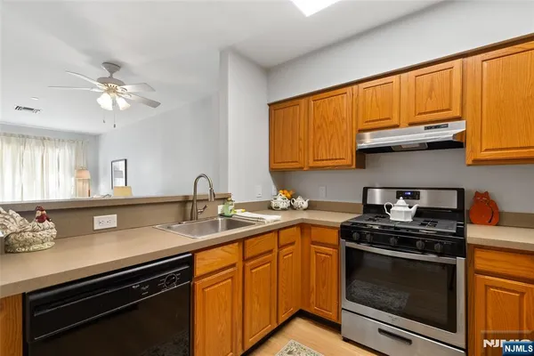 a kitchen with stainless steel appliances granite countertop a sink stove and cabinets