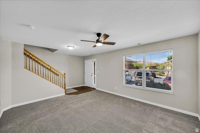 3155 South Hidden Dr Street, Unit 248 St. George, UT 84790 - Photo 3 of 24 Spacious living area featuring neutral carpeting, light-toned walls, and a contemporary ceiling fan