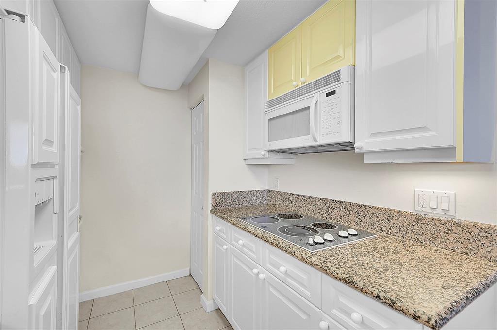 6001 North Ocean Drive, Unit 403 Hollywood, FL 33019 - Photo 12 of 58 a kitchen with granite countertop a sink stove and cabinets