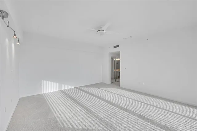 a spacious bathroom with a granite countertop sink a large mirror and a bathtub