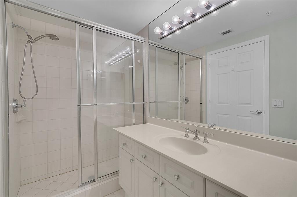 6001 North Ocean Drive, Unit 403 Hollywood, FL 33019 - Photo 28 of 58 a bathroom with a shower sink vanity and mirror