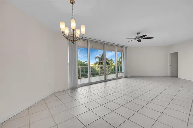 a view of a livingroom with a chandelier fan and windows