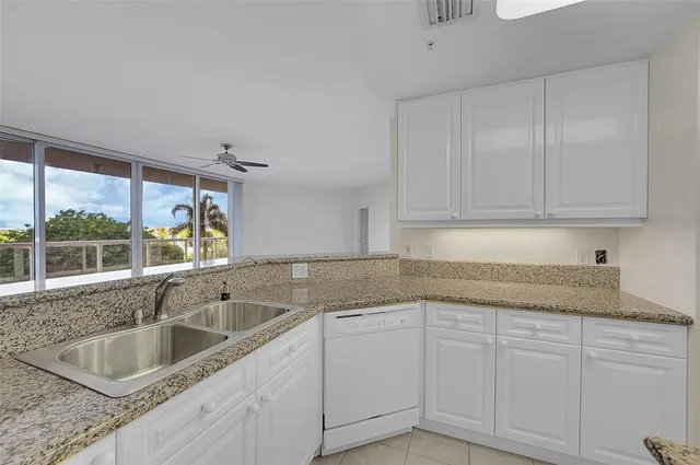 a kitchen with granite countertop a sink stove and cabinets