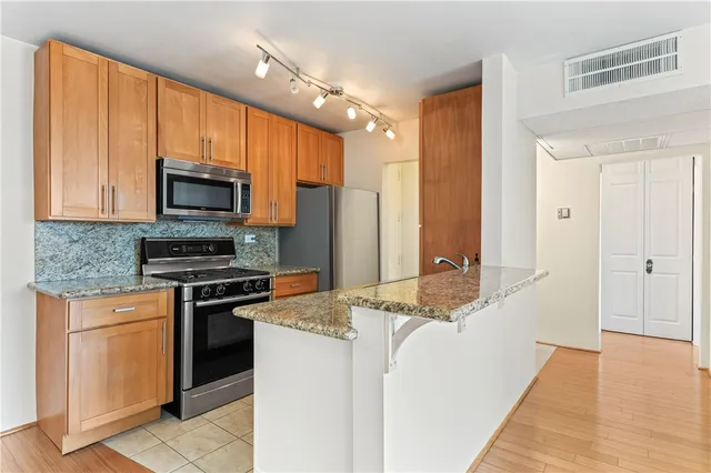 a kitchen with stainless steel appliances granite countertop a stove a sink and a refrigerator