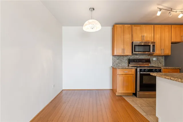a kitchen with granite countertop a stove a sink and a microwave