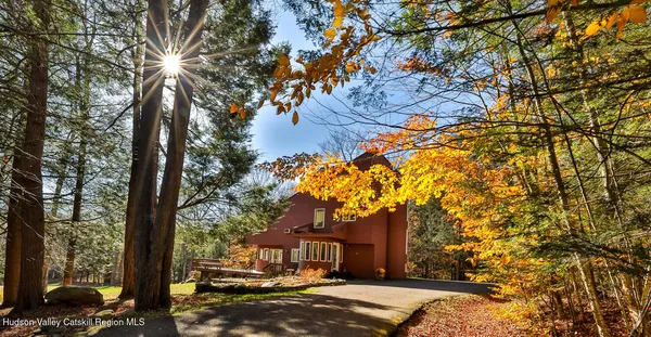 a front view of a house with a yard and trees