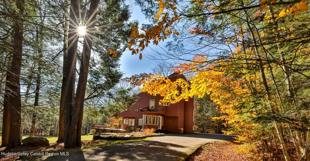 a front view of a house with a yard and trees