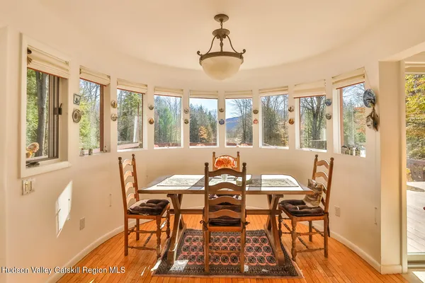 a view of a dining room with furniture large windows and wooden floor