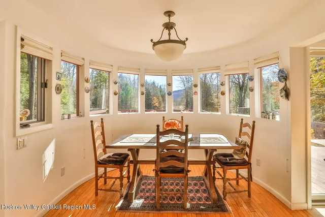 a view of a dining room with furniture large windows and wooden floor