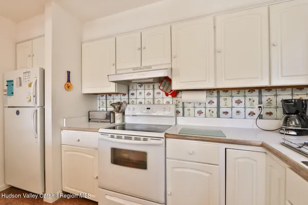a kitchen with white cabinets and white appliances