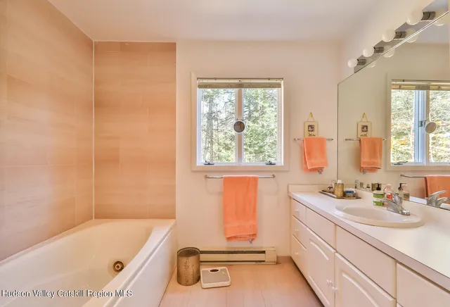 a bathroom with a tub a sink and a window
