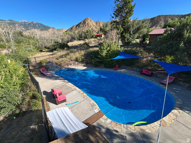 315 Abbey Road Moab, UT 84532 - Photo 43 of 46 View of swimming pool featuring a mountain view, a fenced backyard, and patio surround