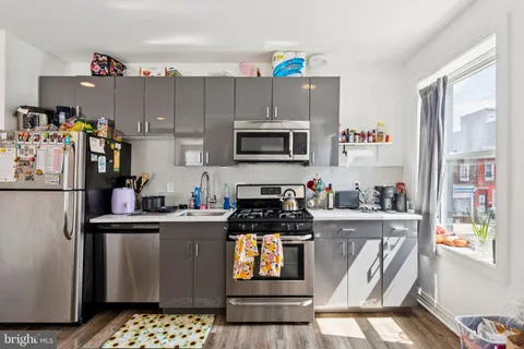 a kitchen with stainless steel appliances granite countertop a stove top oven a sink and cabinets