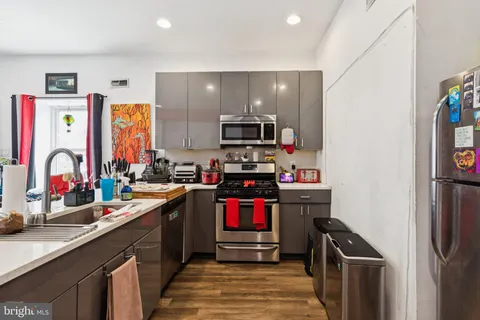 a kitchen with stainless steel appliances granite countertop a refrigerator and a sink
