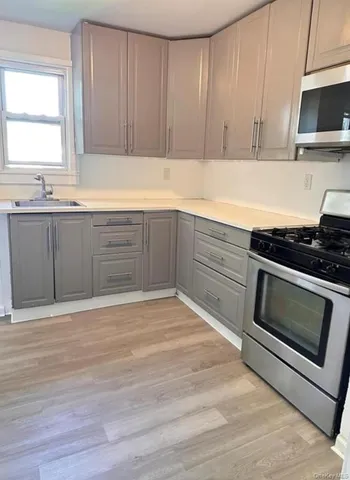a kitchen with granite countertop wooden cabinets and stainless steel appliances