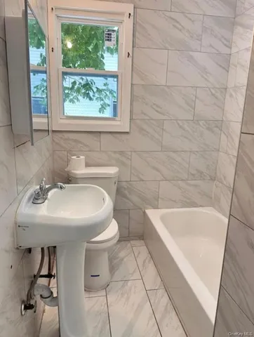 a bathroom with a sink a toilet and bathtub