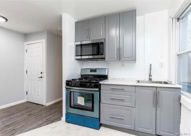 a kitchen with granite countertop cabinets stainless steel appliances and wooden floor