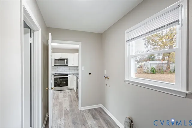 a view of a kitchen from the hallway with a dining table and a window