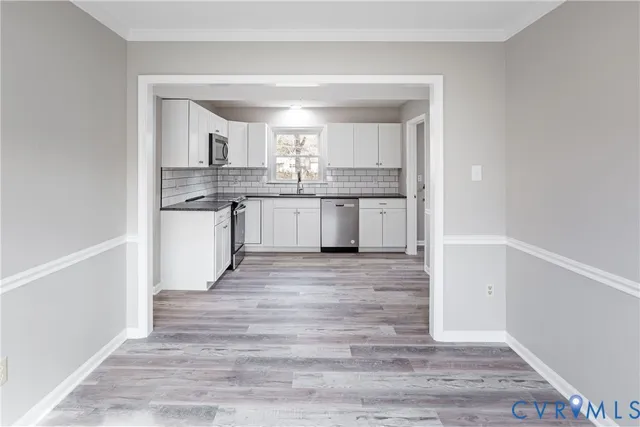 a kitchen with granite countertop a sink cabinets and wooden floor