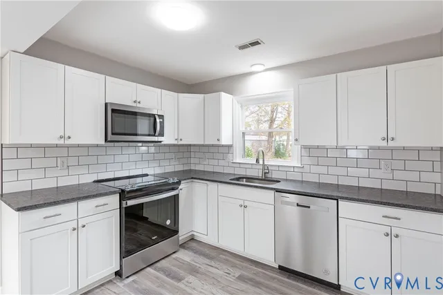 a kitchen with sink cabinets and appliances