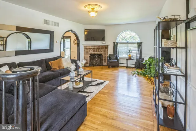 a living room with furniture a fireplace and wooden floor