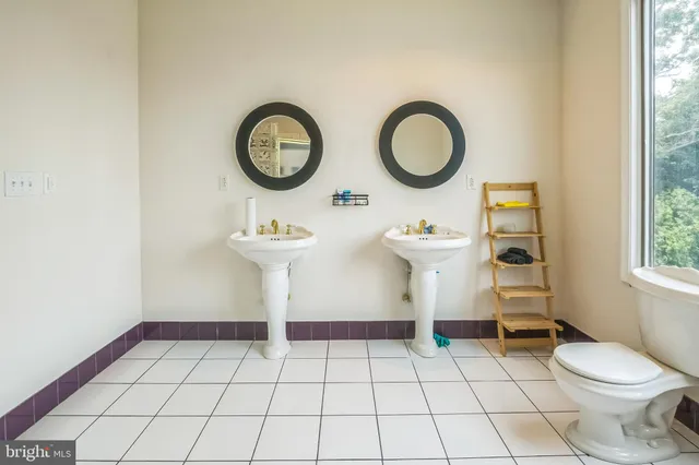 a bathroom with a sink a toilet and a window