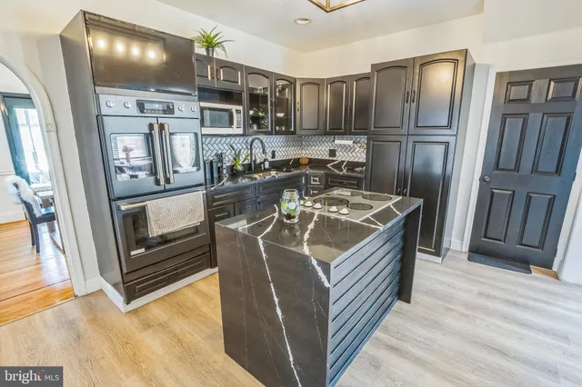 a kitchen with stainless steel appliances granite countertop a refrigerator stove and sink