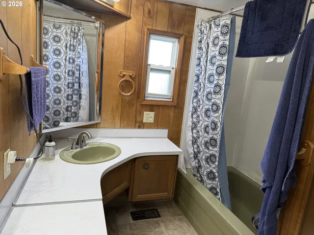 a bathroom with a granite countertop sink a mirror a shower curtain and a sink