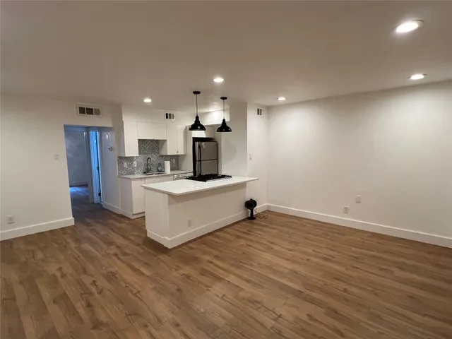 a view of kitchen with refrigerator sink and wooden floor
