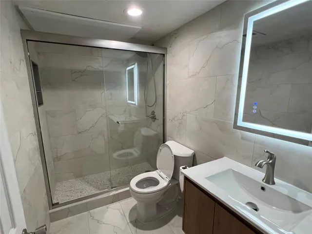 an empty room with wooden floor mirror and windows